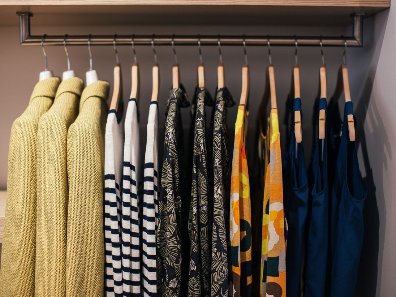 Clothes hanging in a row on a closet rail