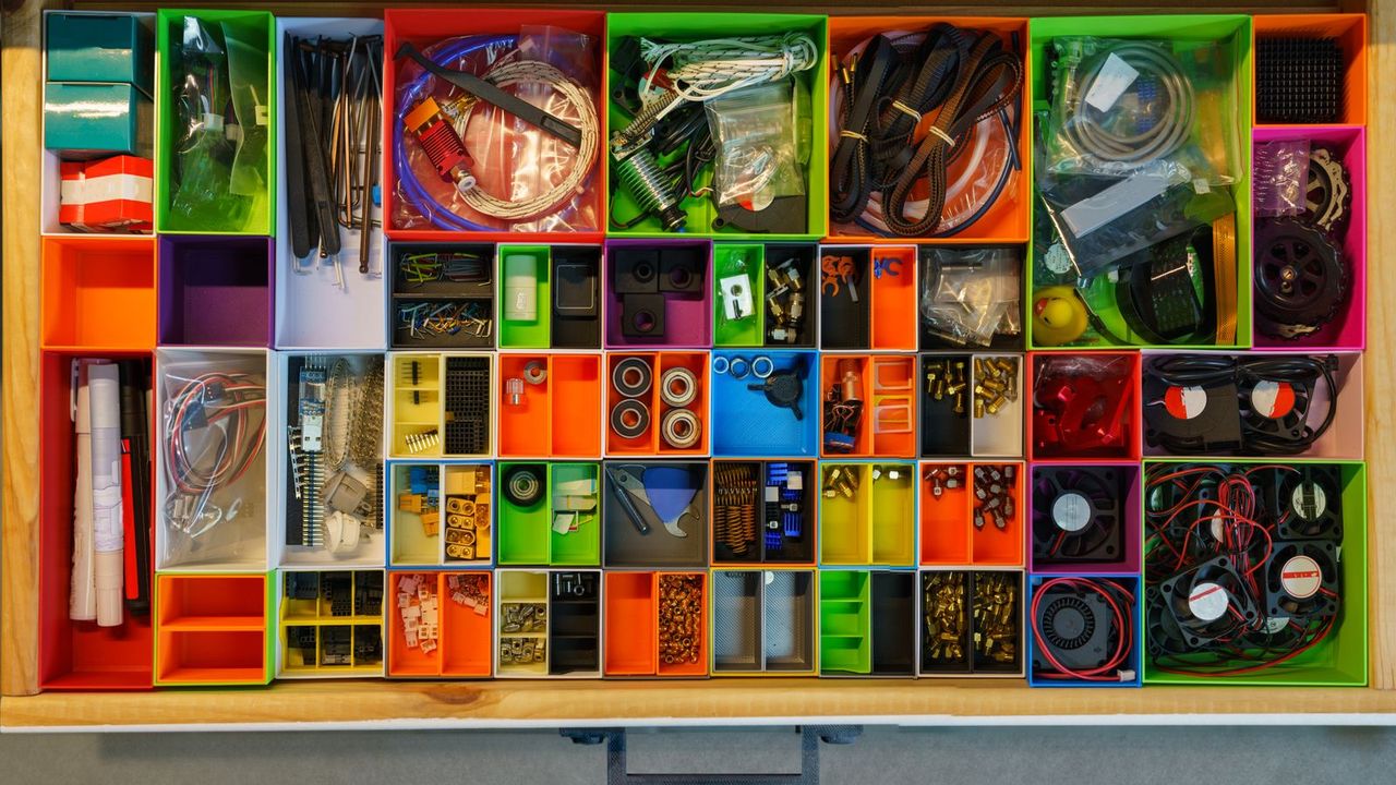 A drawer sorted into small colored compartments