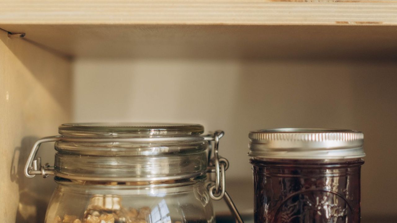 Jars and plates lined up on cabinet shelves