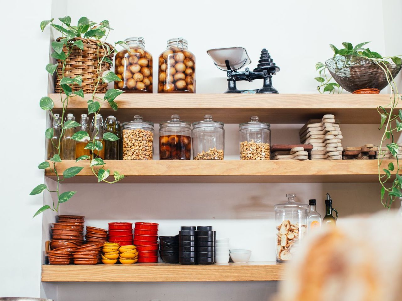 Glass jars and bowls arranged on open kitchen shelves