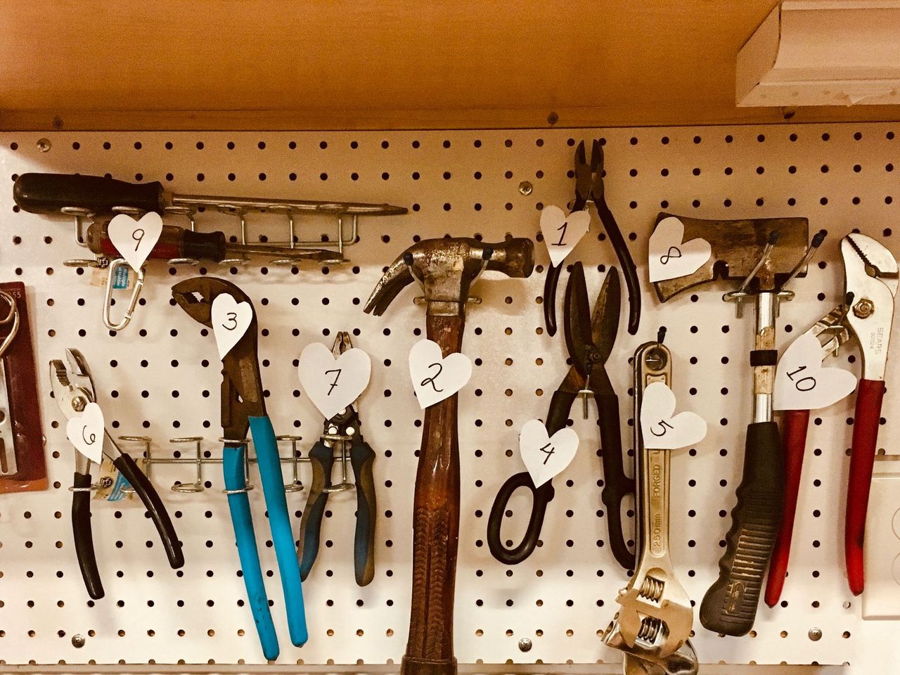 Hand tools hanging in order on a garage pegboard